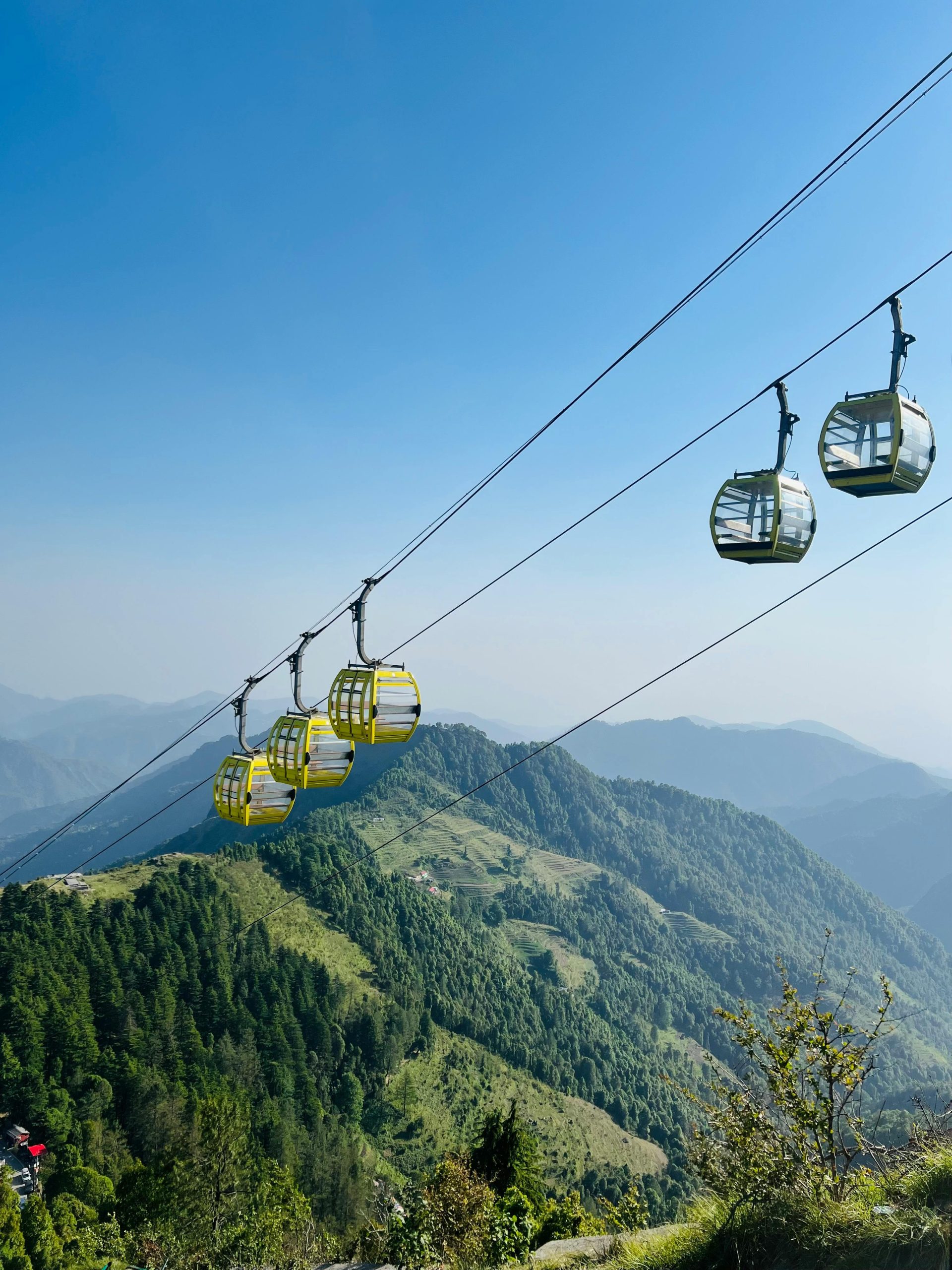 A breathtaking view of cable cars traversing the lush green mountains of Mussoorie, India.